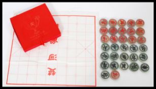A set of thirty two Chinese jade gaming counters / draught pieces complete in fitted case. Box