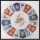 A 19th century Japanese Imari charger plate having a central cartouche panel with dog to centre with