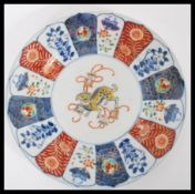 A 19th century Japanese Imari charger plate having a central cartouche panel with dog to centre with