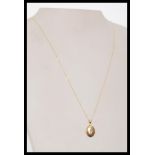A hallmarked 9ct gold locket pendant necklace set on a fine 9ct gold necklace chain.