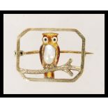A 10ct gold brooch having an enamel owl with natural pearl to the body. Measures 2.3 cms wide and