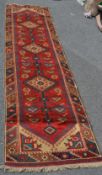 A 20th century Persian / Islamic red ground runner carpet floor rug. The design set on red ground