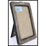 A silver hallmarked picture frame being easel backed. Embossed frame having floral decoration.