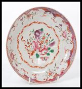 An 18th century Chinese famille rose plate hand painted with scenes of flowers and decorative