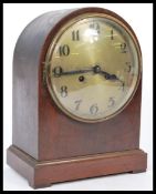 An Edwardian mahogany spire cased mantel clock with silvered dial and an inset 8 day brass