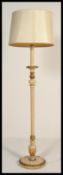 A 20th century tall standard lamp raised on a circular base with central reeded column. White