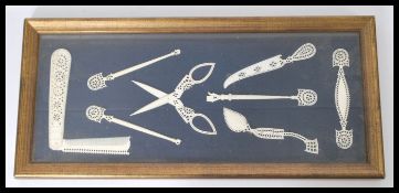 A set of 19th century carved ivory items displayed in a gilt frame. Including scissors, combs etc.