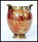 A Crown Devon Fieldings rouge ware twin handled vase of bulbous form depicting birds of paradise.