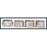 A collection of 4 silver hallmarked napkin rings to include a pair and 1 by E Silver & Co,