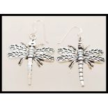 A contemporary pair of silver dragon fly earrings with articulated wings. They are 3.5cm in length.