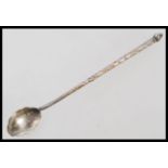 A 19th century large silver white metal mote spoon having an engraved stem with scalloped bowl.