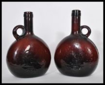 A pair of 19th century Dutch amber glass wine flask bottles having moon flask shaped bodies with