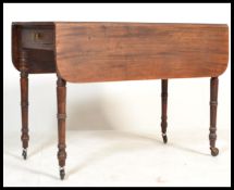 A 19th century George III mahogany pembroke dining table being raised on ring turned legs with