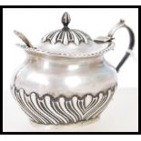 A silver hallmarked condiment pot with lid complete with blue glass liner. The silver hallmarked for