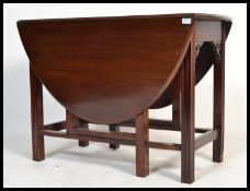 A 19th century Victorian mahogany drop leaf dining table being raised on squared legs united by