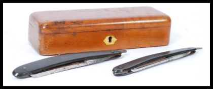 A 19th century walnut razor box having two cutthroat shaving  razors inside. Please see images.