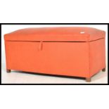 A vintage retro 20th century orange ottoman blanket box finished in a vibrant orange leatherette.