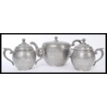 An early 20th century Chinese silver plate three piece tea service of bulbous form with engraved