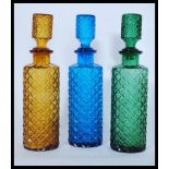 A collection of three vintage / retro 20th Century studio art glass decanters / bottle, each in a