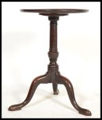 A 19th century George III mahogany tripod wine table. Raised on splayed legs with turned column