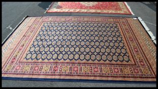 A 20th century Persian Bokhara rug having central multiple medallions raised on blue and red