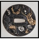 A 20th century bronze Japanese tsuba bearing impressed character marks and embossed decorations of a