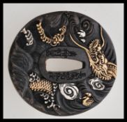 A 20th century bronze Japanese tsuba bearing impressed character marks and embossed decorations of a