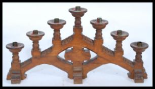 An early 20th century oak ecclesiastical menorah candelabra having a graduating configuration of