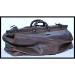 A vintage early 20th century large doctors leather Gladstone bag with carry handle atop. Please