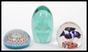 A group of glass paperweights to include a 19th century Nailsea glass dump paperweight with inset