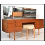 A vintage retro 20th century teak knee hole dressing table desk having a configuration of seven