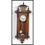 A vintage 20th century Vienna Regulator style mahogany cased wall clock having an arched pediment