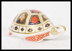 A Royal Crown Derby paperweight in the form of a turtle, gold stopper stamped to base. Measures
