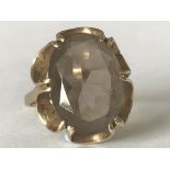 A hallmarked 9ct gold ring having large central smokey quartz stone set in an open prong mount.