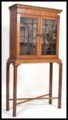 An Edwardian mahogany display cabinet on stand having cross stretchers to the base, display