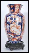 A 19th century Japanese Imari vase having hexagonal panels to the body with tapered neck and