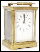 A square early 20th century brass cased carriage clock having a white enamel face with Roman numeral