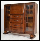 A 1930's Art Deco oak bureau bookcase display cabinet. Raised on onion feet with upright twin