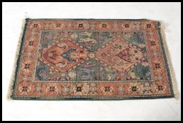 A 20th century Egyptian carpet rug having a blue and red ground with central diamond panels