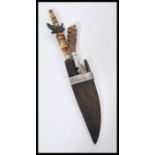 A 19th century Mongolian dagger knife carving set ion wooden sheaf having carved bone handles.