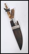 A 19th century Mongolian dagger knife carving set ion wooden sheaf having carved bone handles.