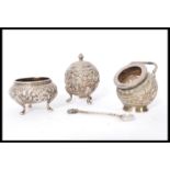 A set of three Persian Indian silver condiments cruets having embossed scroll work and flower head