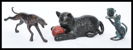 A bronze figurine of a lurcher dog along with a bronze cat candle holder and a Bretby black cat with