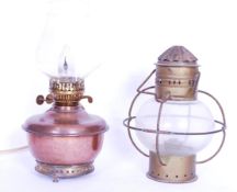 Two vintage early 20th century copper oil lamps, one having a globular glass body with wire cage.