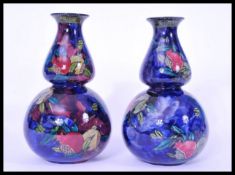 A pair of vintage gourd vases by Rubens ware shape 6767. Globular bodies with deep blue ground