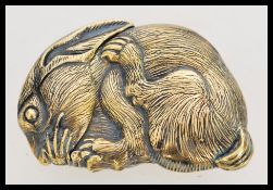A 20th century novelty brass vesta case in the form of a rabbit featuring a hidden hinge
