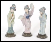 A group of three pieces of Lladro porcelain figures modelled as Geisha girls to include Madam
