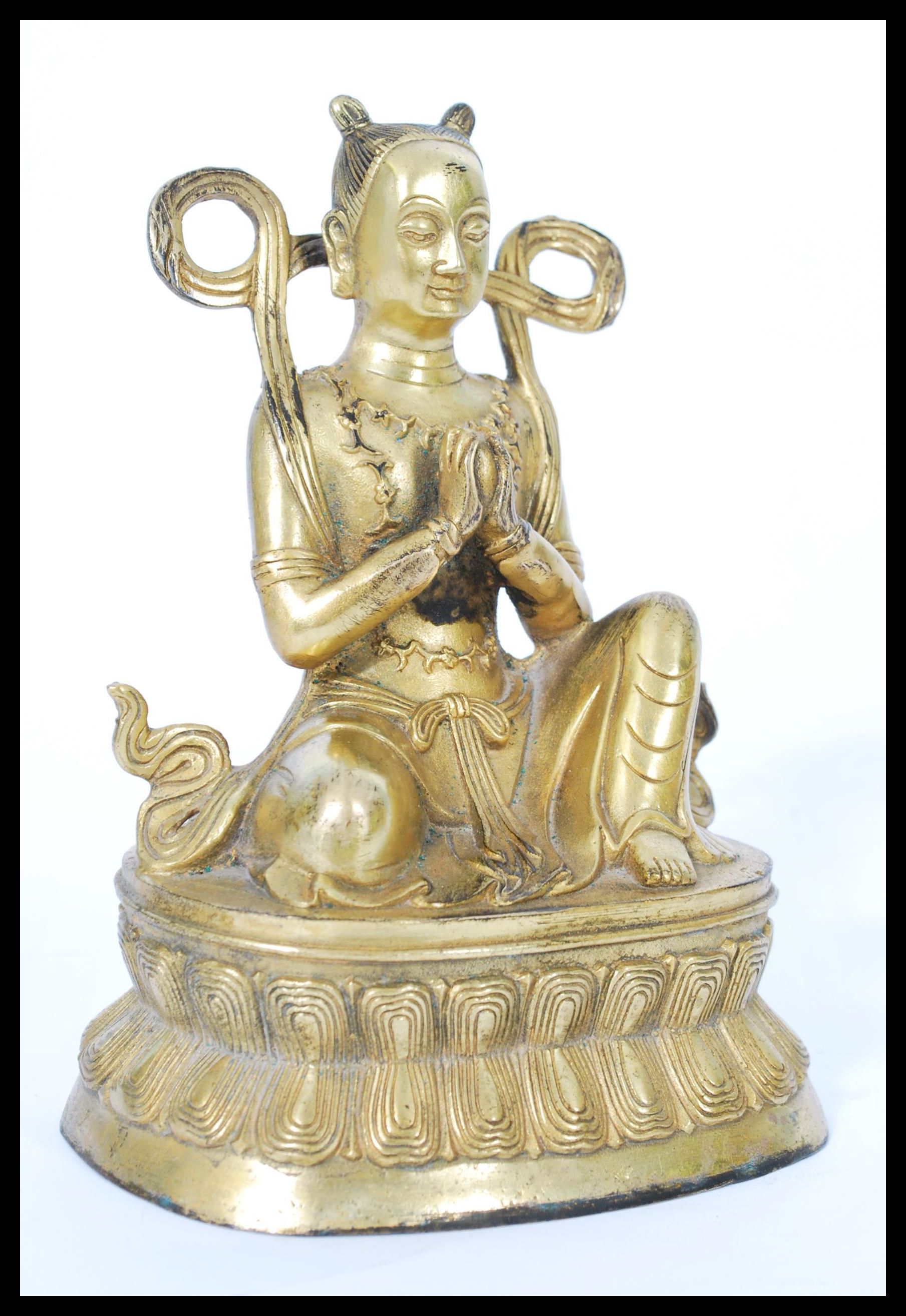 A 19th century gilt bronze statue of a Buddha raised on pedestal base with scrolled robe and