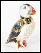 A Royal Crown Derby porcelain puffin paperweight, gold button stamped to base. Measures 12cms high.