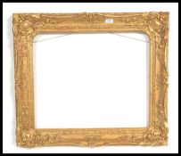 A large 19th century gilt wooden frame having ormolu moldings of scrolls and flowers. Measures 68 cm